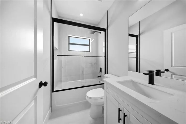 Full bathroom featuring bath / shower combo with glass door and vanity