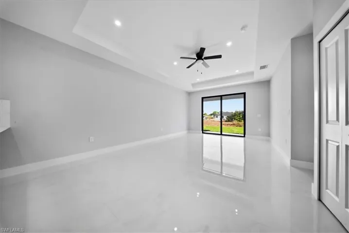 Unfurnished room with recessed lighting, a tray ceiling, and a ceiling fan