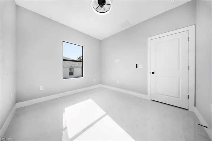 Unfurnished room with baseboards and finished concrete flooring