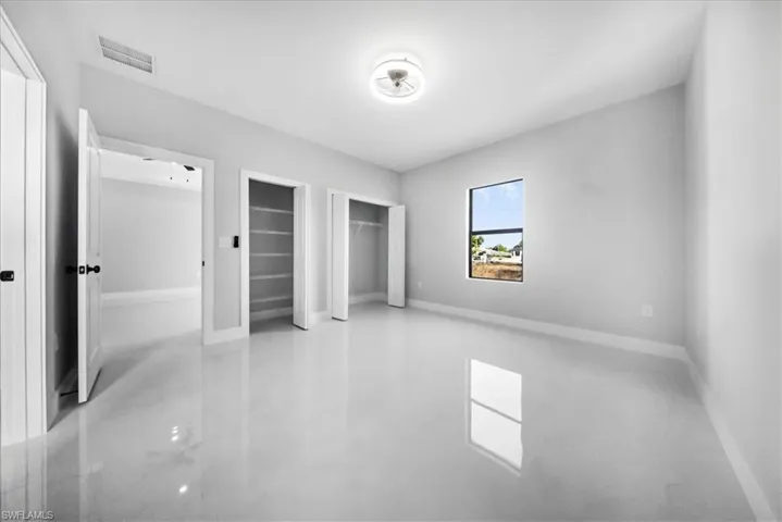 Unfurnished bedroom featuring multiple closets and baseboards