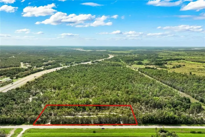 Expansive wooded property featuring mature tree coverage across multiple acres, with direct access via paved road frontage