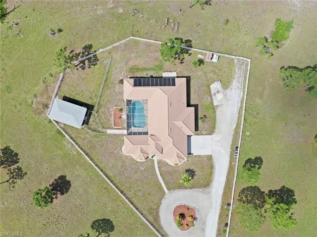 Property featuring a tiled roof, screened swimming pool, and an outbuilding