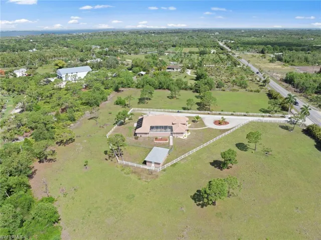 Expansive property featuring a single-story residence with an attached screened-in lanai and a circular driveway