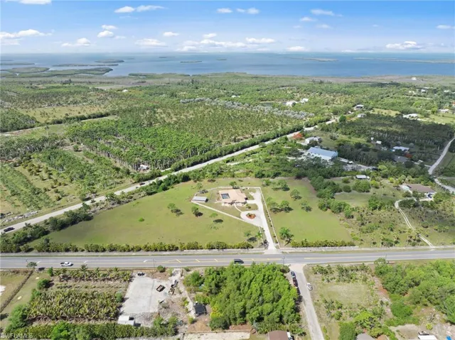 Expansive property featuring significant acreage, a large main dwelling with a private pool, and mature trees