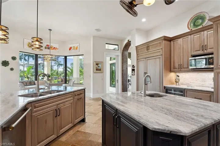 Kitchen with a chandelier, a center island with sink, appliances with stainless steel finishes, and sink