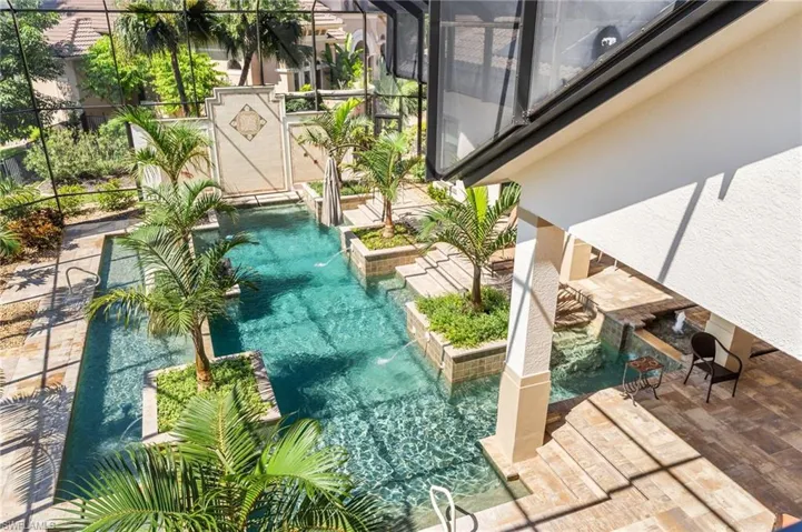 View of patio with pool water feature and a lanai