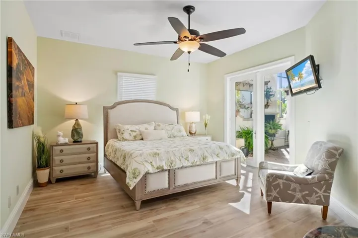Bedroom featuring ceiling fan, light wood-type flooring, access to exterior, and multiple windows