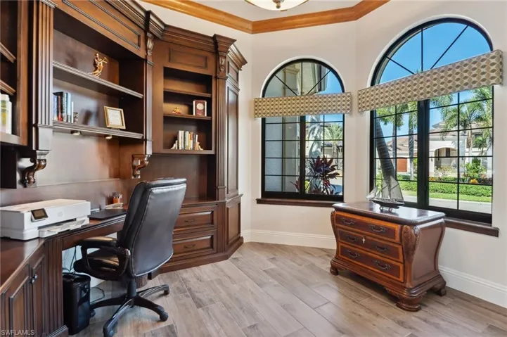 Office space with light hardwood / wood-style flooring, a wealth of natural light, and crown molding