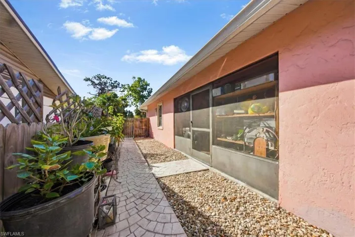View of side of home with stucco siding and a sunroom