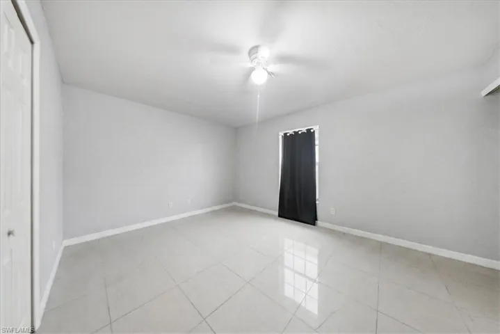Spare room featuring light tile patterned flooring and ceiling fan