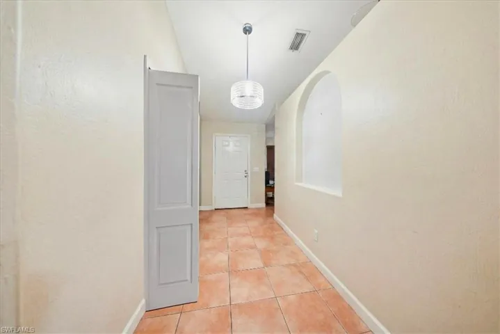 Corridor featuring light tile patterned floors and baseboards
