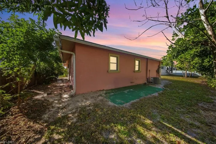 Back of property at dusk featuring stucco siding and a patio area