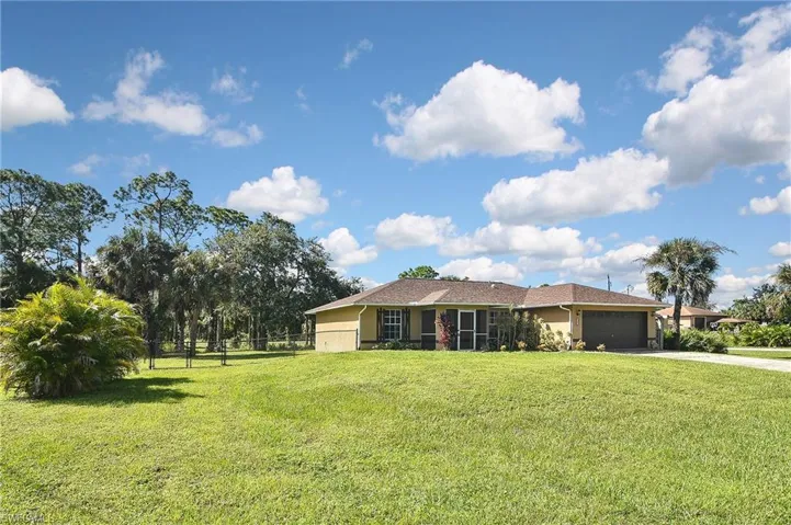 Ranch-style home featuring a garage and a front yard