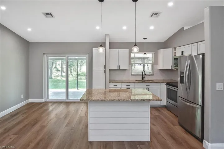 Kitchen featuring white cabinets, appliances with stainless steel finishes, sink, and a center island