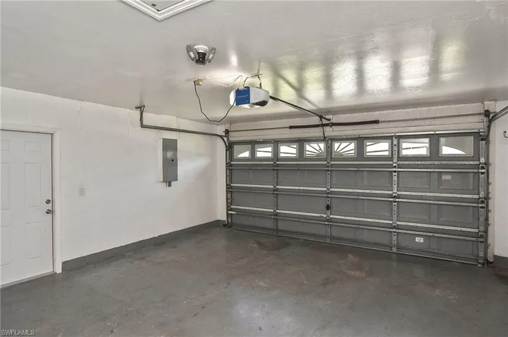 Garage featuring electric panel and a garage door opener