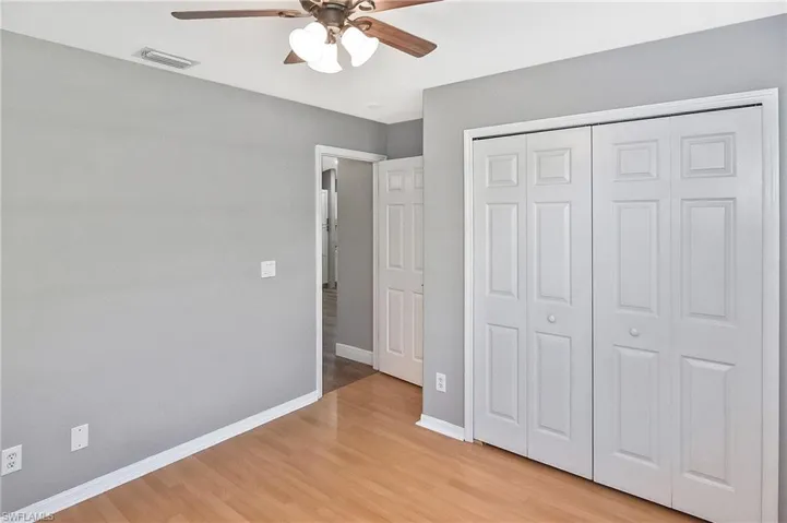 Unfurnished bedroom with ceiling fan, light wood-type flooring, and a closet