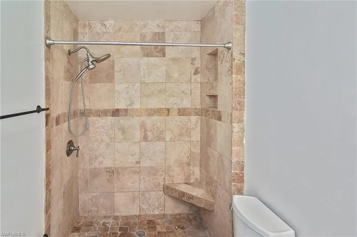 Bathroom with a tile shower and toilet