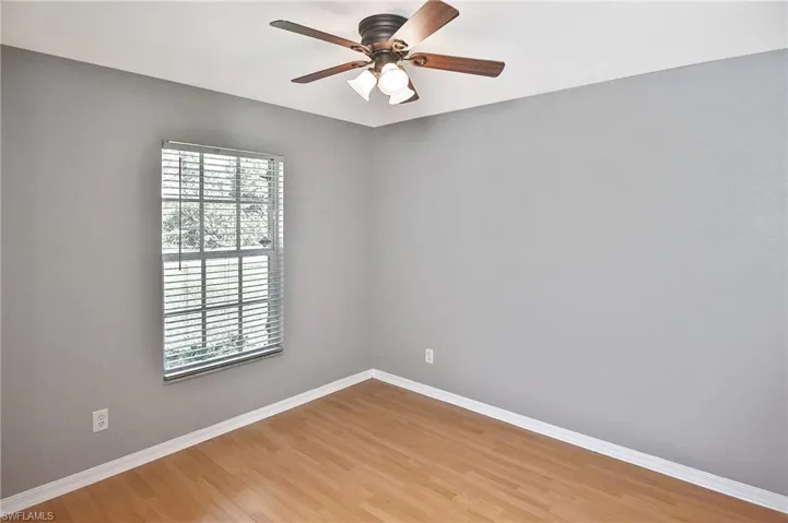 Unfurnished room featuring ceiling fan, plenty of natural light, and hardwood / wood-style floors