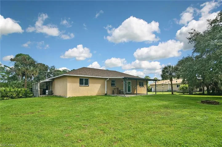 Rear view of property featuring a yard, a patio, and central AC