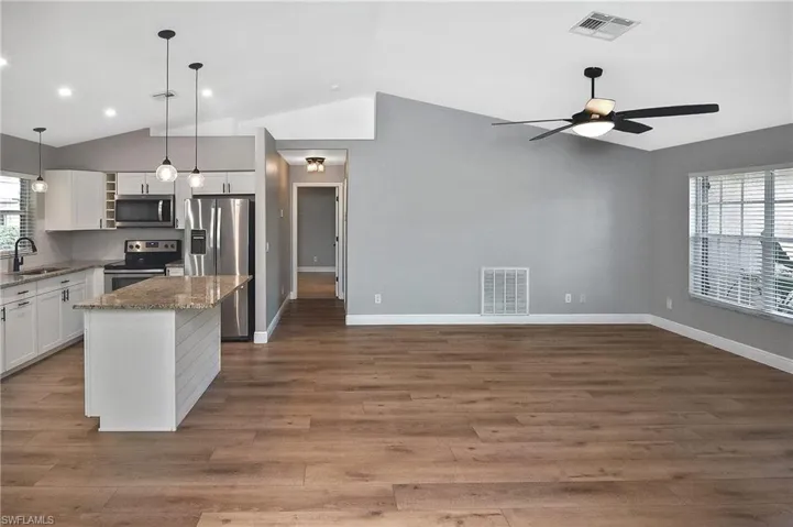 Kitchen featuring a center island, appliances with stainless steel finishes, a healthy amount of sunlight, and sink