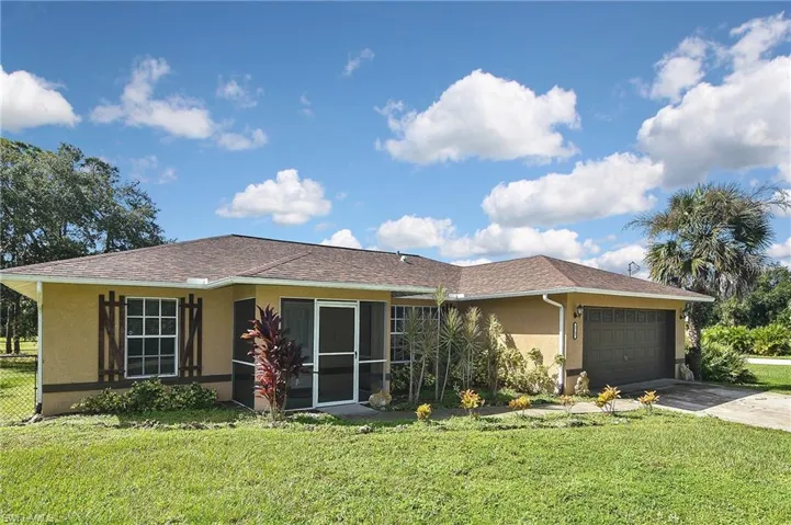 Ranch-style home featuring a garage and a front yard
