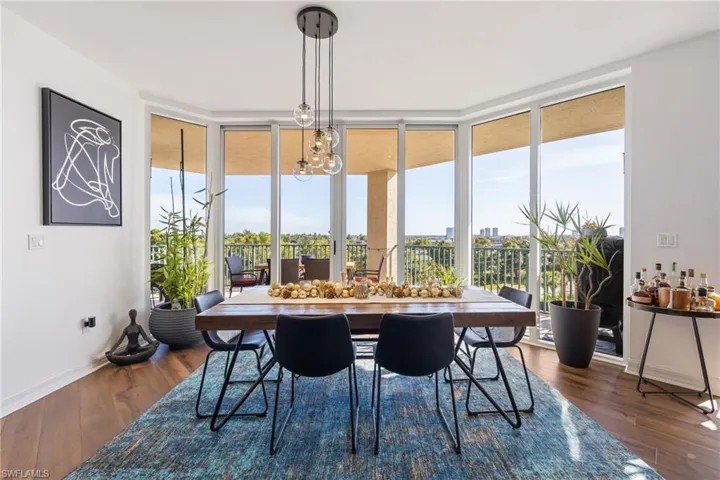 Dining room with a chandelier, a wall of windows, and dark wood finished floors