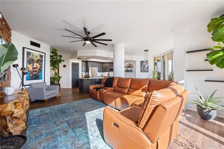 Living area with dark wood-type flooring and ceiling fan