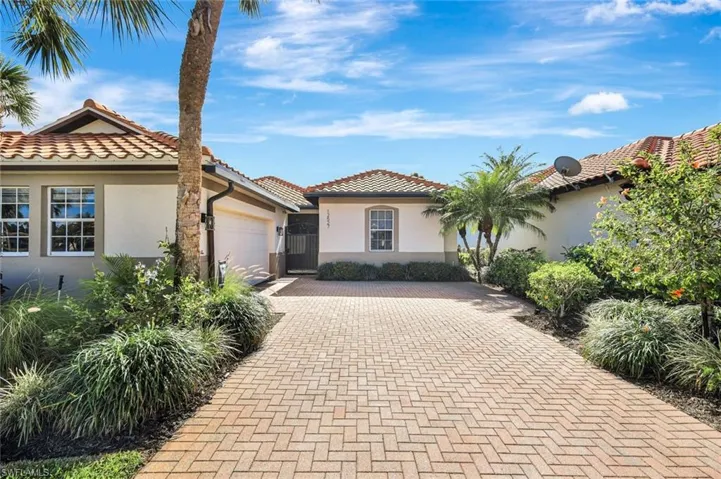 Mediterranean / spanish-style home featuring stucco siding, a tile roof, an attached garage, and decorative driveway