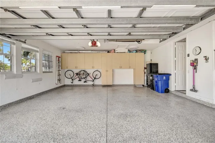 Garage featuring a garage door opener and baseboards
