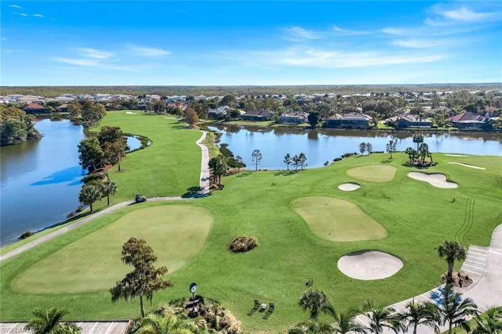 Aerial view of residential area featuring a nearby body of water and a golf course