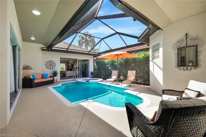 View of swimming pool with a sunroom, a patio, glass enclosure, and an outdoor hangout area