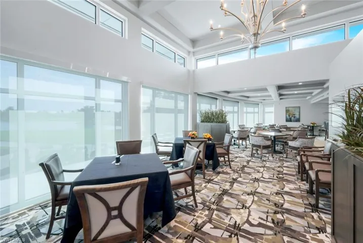 Dining room featuring beamed ceiling, a towering ceiling, and a chandelier