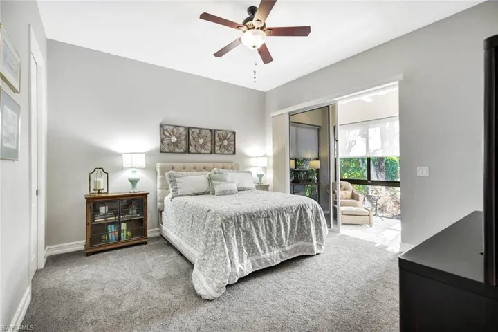 Carpeted bedroom with ceiling fan and access to exterior