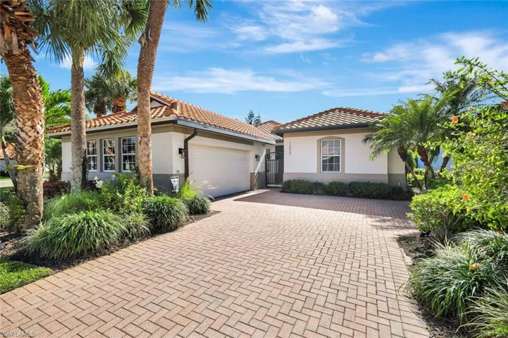 Mediterranean / spanish-style house featuring stucco siding, a gate, decorative driveway, a garage, and a tiled roof