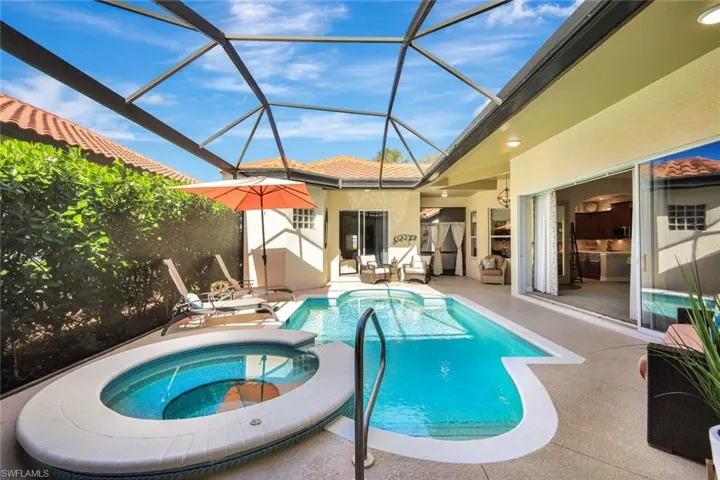 View of swimming pool with a sunroom, a patio area, glass enclosure, and a pool with connected hot tub