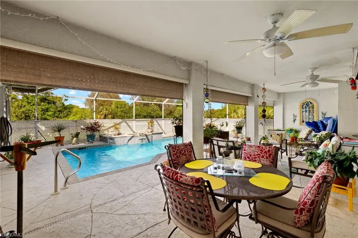 View of swimming pool with a fenced in pool, a ceiling fan, a patio, a fenced backyard, and a lanai