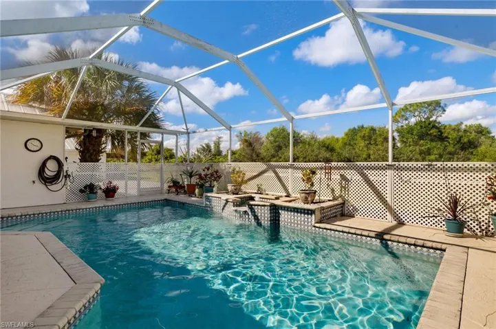 View of pool with glass enclosure and a fenced in pool