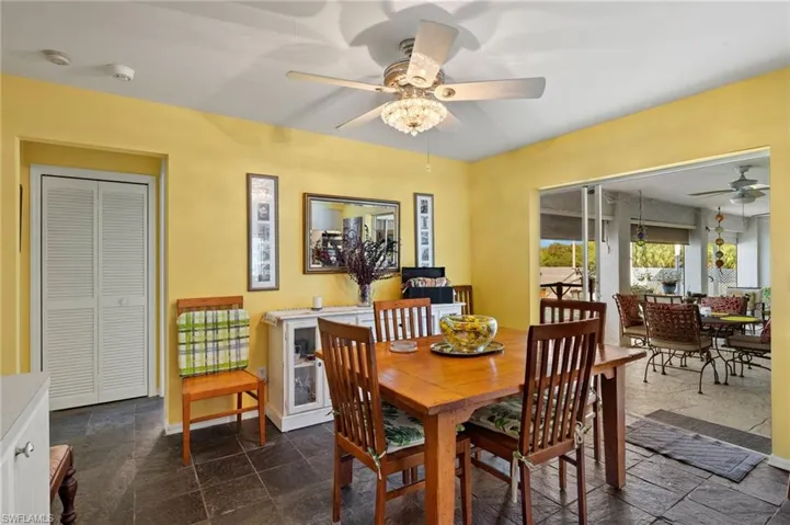 Dining area featuring a ceiling fan, stone finish flooring, and baseboards