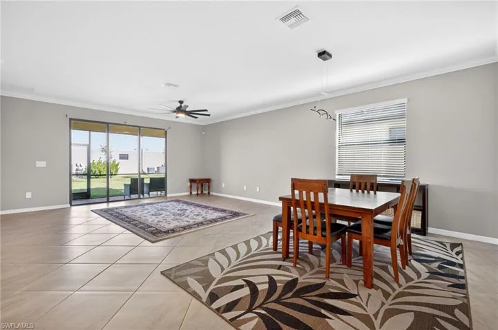 Dining space featuring crown molding, ceiling fan, and light tile patterned flooring