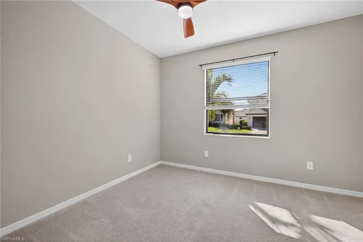 Unfurnished room featuring light colored carpet and a ceiling fan