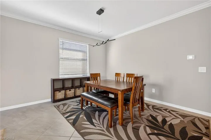 Dining space with ornamental molding and baseboards