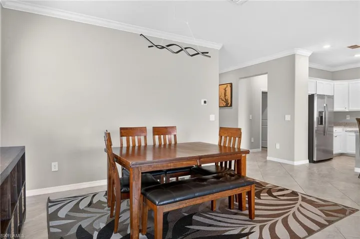 Dining room with crown molding, light tile patterned flooring, and recessed lighting