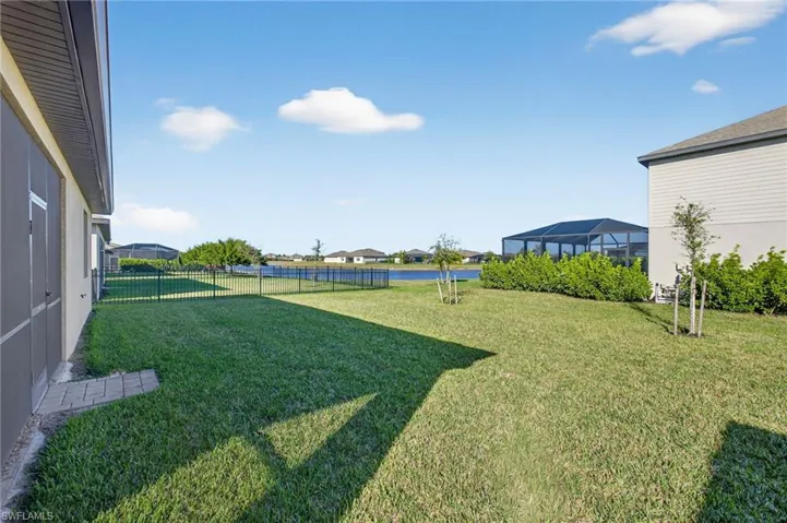 Fenced yard with a water view, a sunroom, a residential view, and a lanai
