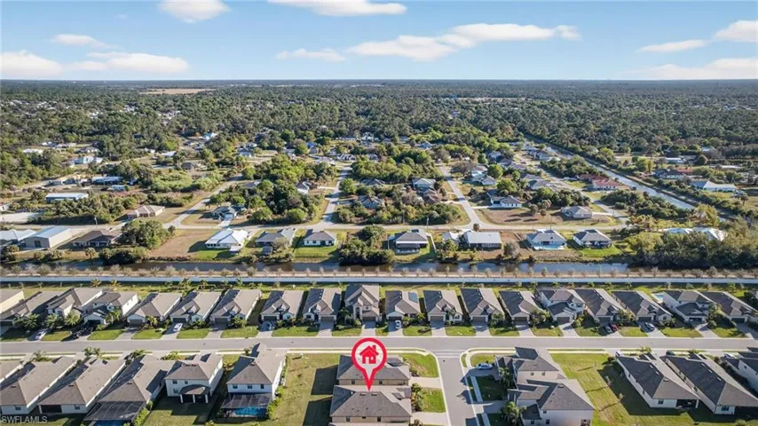 Aerial view of property and surrounding area with nearby suburban area