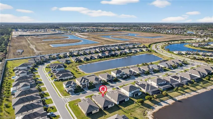 Aerial view of property and surrounding area with nearby suburban area and a large body of water