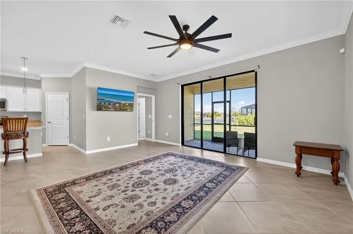 Unfurnished living room with crown molding and ceiling fan