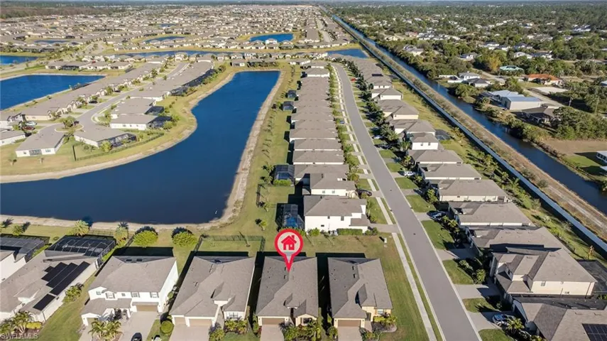 Aerial view of property and surrounding area featuring nearby suburban area and a nearby body of water