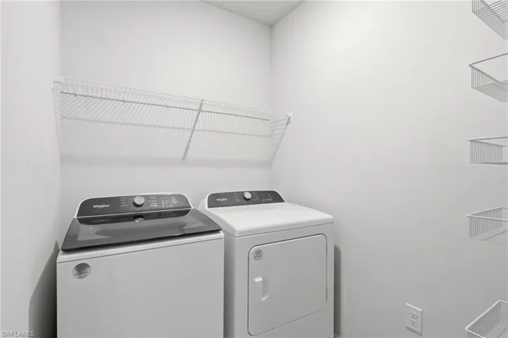 Dedicated laundry area featuring white walls and built-in wire shelving