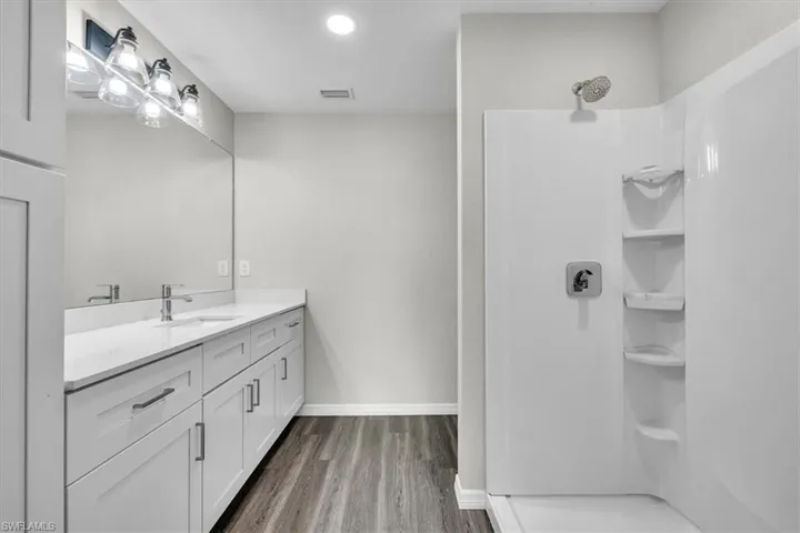 Full bath featuring vanity, a shower stall, recessed lighting, and light wood-type flooring