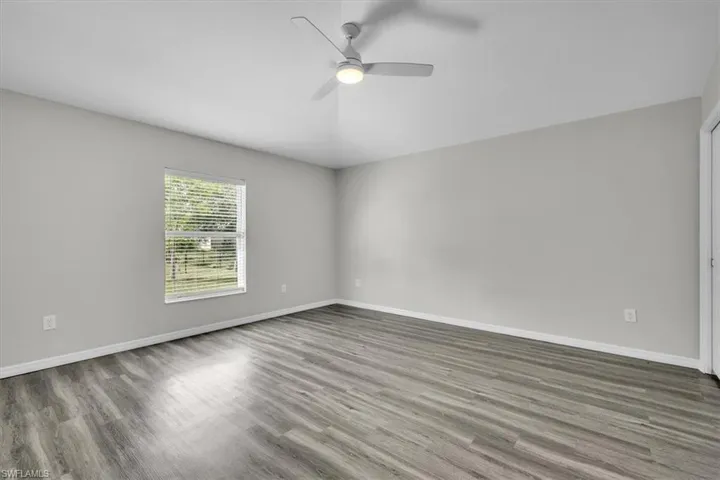 Unfurnished room with wood finished floors and a ceiling fan